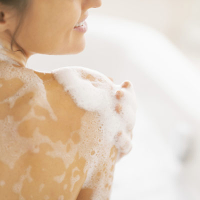 closeup on young woman washing in bathtub. rear view